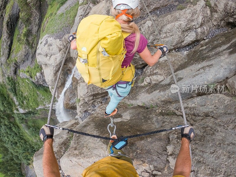 Via Ferrata上的年轻女性正在攀爬岩石